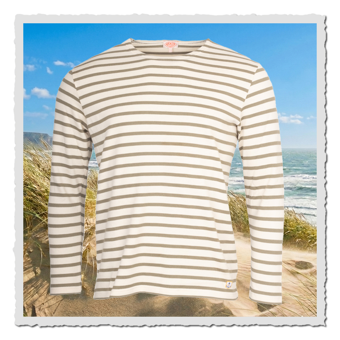 Gestreiftes Matrosenshirt in natur-weiß und khaki vor Dünenkulisse am Meer, langer Ärmel, klassischer Rundhals und dezentes Anker-Emblem.